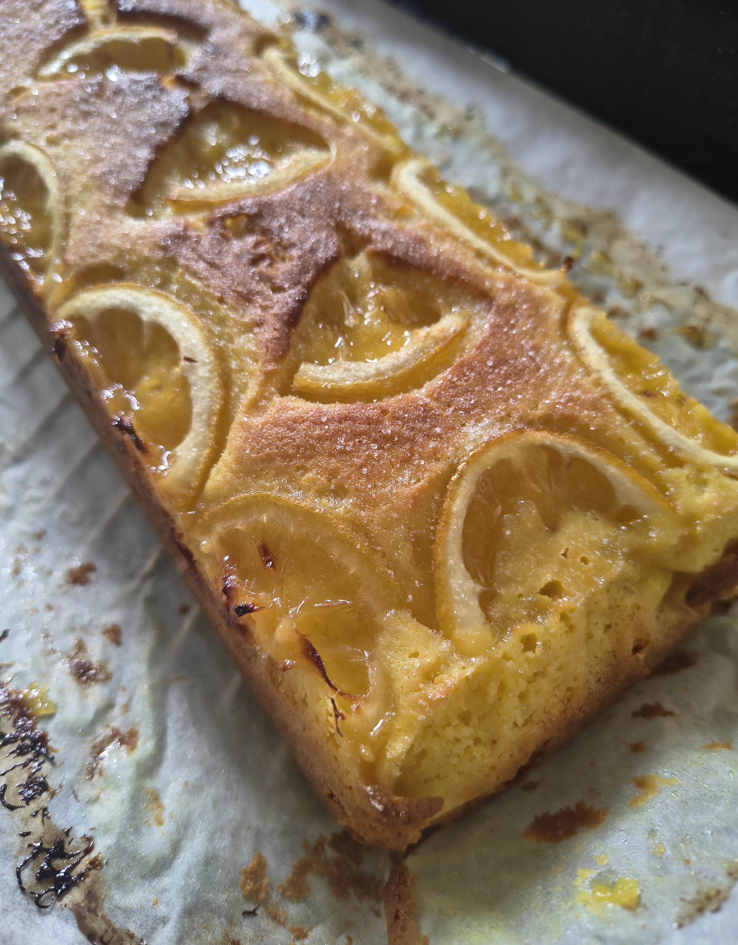 El bizcocho al sacarlo del papel de horno. Tiene un color amarillo muy intenso y la parte superior está un poco caramelizada.