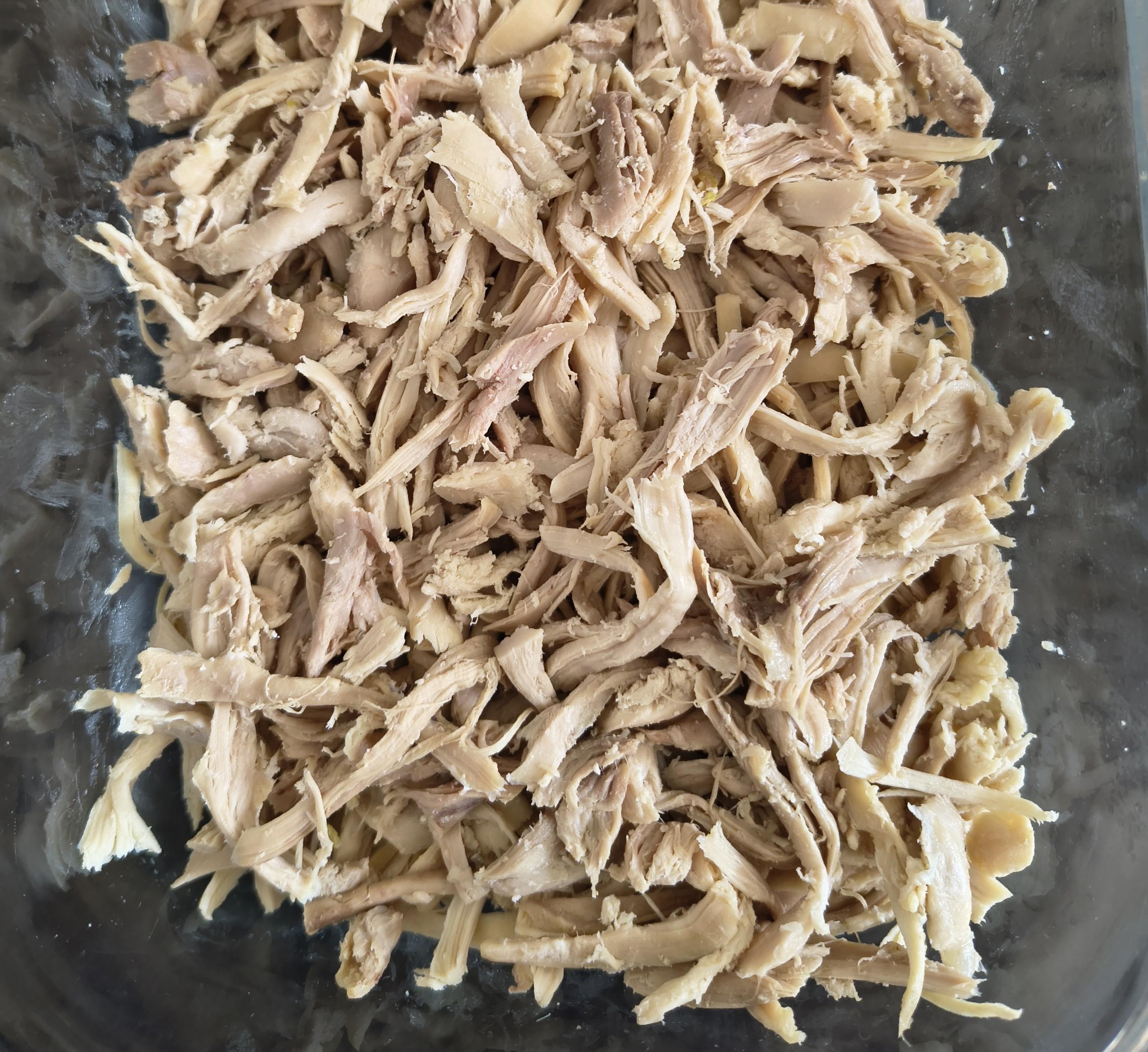 Hebras de pollo cocido en un tupper