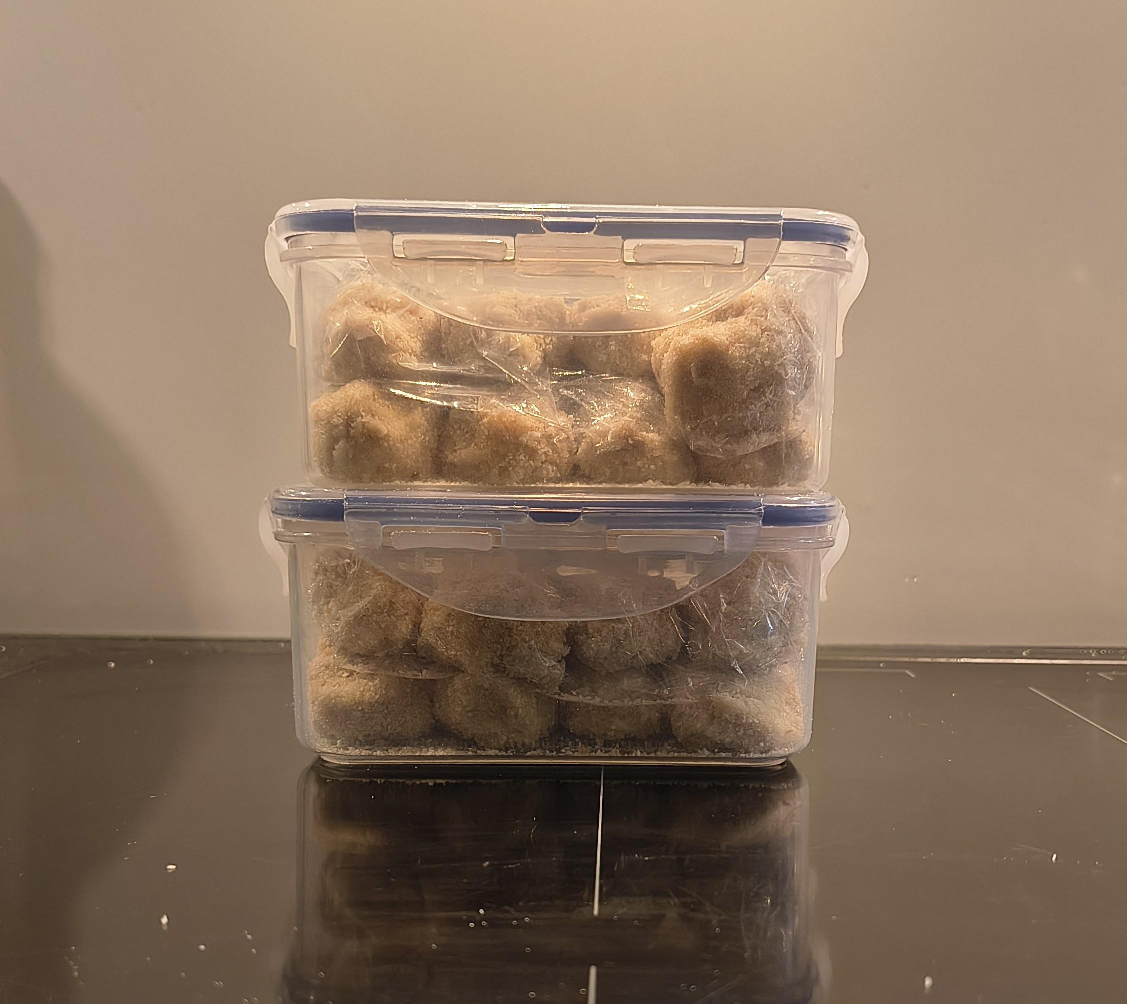 Dos tuppers apilados, con 8 croquetas cada uno.